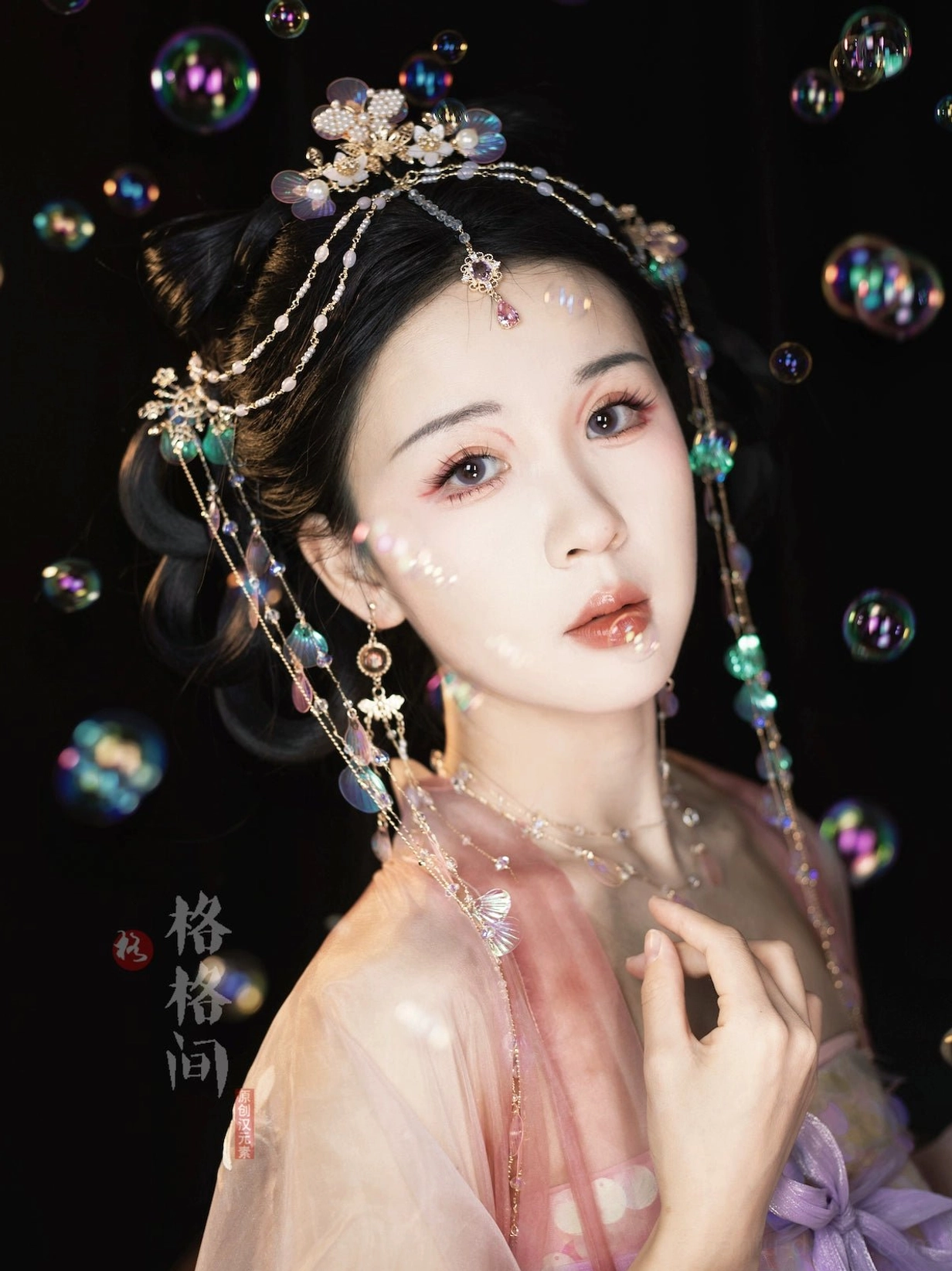 Model wearing pink Hanfu styled with mermaid shell tassel hair pins floral headpiece and forehead chain in a dreamy fairy themed setting