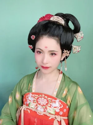 Woman wearing a red Tang-style Hanfu outfit and traditional coiled hairstyle decorated with Chinese ginkgo leaf hair pins and elegant Hanfu hair accessories