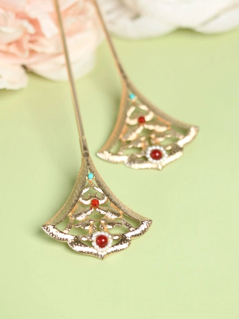 Top view of matching traditional Chinese ginkgo leaf hair pins arranged on a light green background with pink peony flowers and colorful bead details