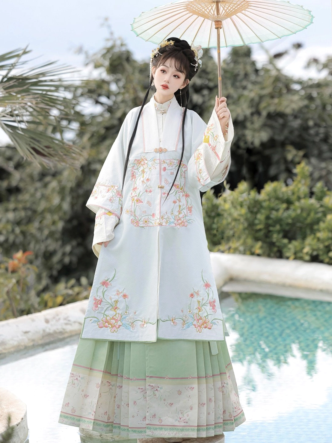 Blue Ming Dynasty inspired Hanfu outfit with embroidered robe and pleated mamian skirt styled with a bamboo oil-paper umbrella