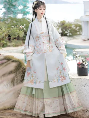 Blue Ming Dynasty Hanfu set with embroidered square-collar robe and layered mamian skirt photographed beside a garden stone pool