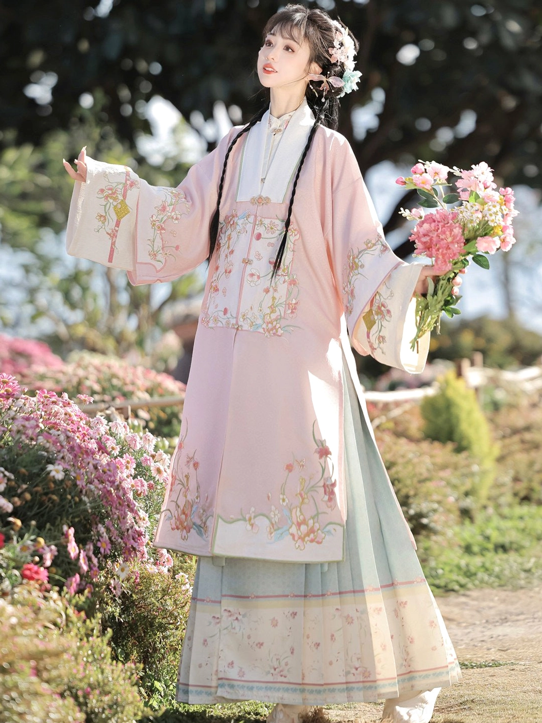 Side view of pink Ming Dynasty Hanfu robe with floral embroidery and light blue printed mamianqun skirt in blooming flowers