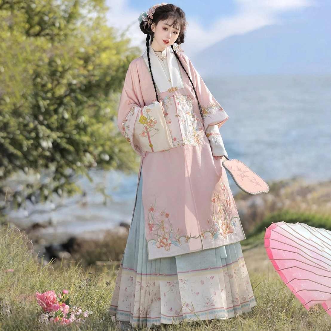 Rear side view of pink Ming Dynasty Hanfu full set with floral embroidered robe and mamian skirt in a lakeside spring landscape