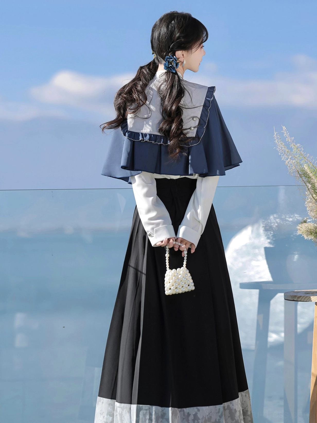 Back view of midnight scholarly modern Hanfu outfit showing ruffled shawl edge and embroidered horse face skirt