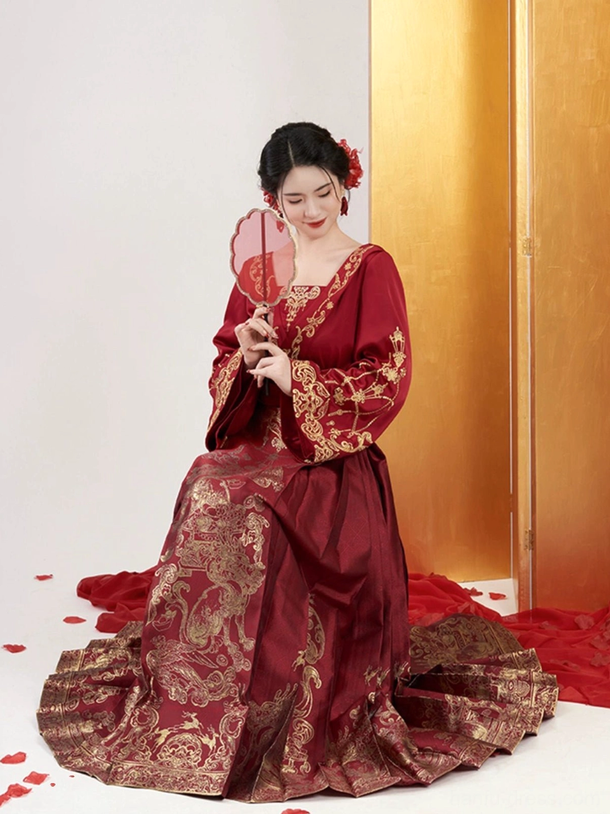 Seated bridal portrait in crimson Ming Dynasty wedding Hanfu with gold brocade Mamian skirt and red silk fan