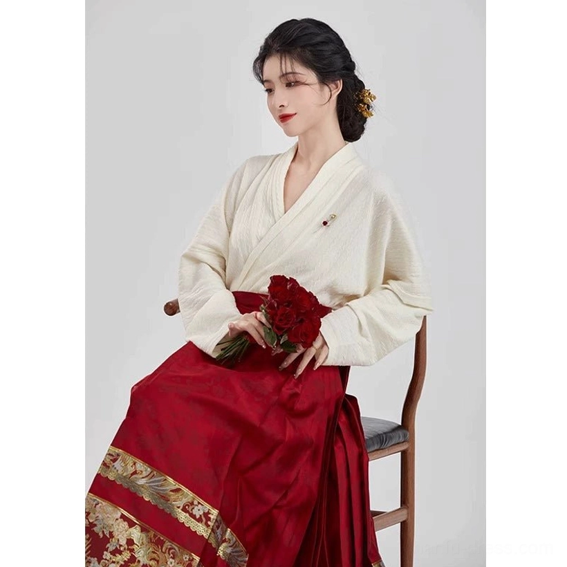 Close view of Ming Dynasty inspired bridal Hanfu showing the wine-red mamian skirt and wide gold patterned ceremonial hem