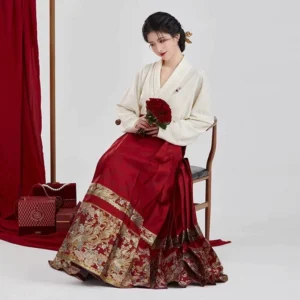 Seated bride wearing Ming Dynasty inspired red wedding Hanfu with winged sleeve top and gold hem mamian skirt for Chinese tea ceremony
