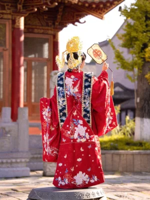 Rear full-body view of a bride wearing a red Ming Dynasty Chinese wedding Hanfu with peony and phoenix embroidery, blue and gold shoulder decorations, grand wedding crown, and traditional hand fan