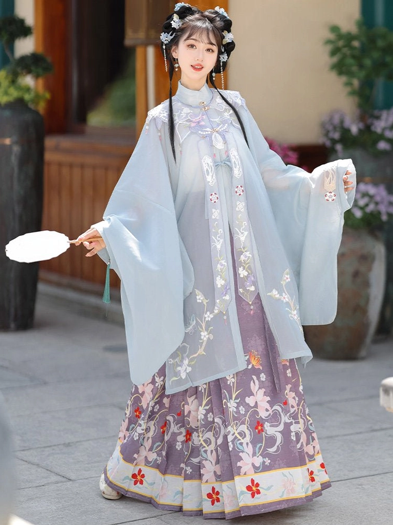 Ming Dynasty Hanfu full set with light cyan embroidered stand collar robe, purple floral mamian skirt, cloud collar, and decorative red hem in a traditional Chinese garden