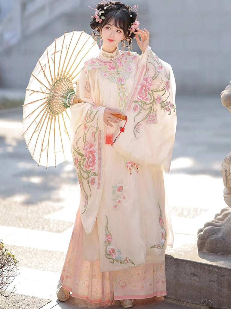 Ming Dynasty Hanfu set with embroidered cloud collar and pink pleated mamian skirt worn by a woman holding a traditional oil paper umbrella outdoors