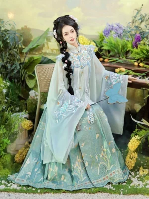 Side view of a woman wearing an elegant Ming Dynasty Hanfu embroidered robe and flowing mamian skirt beside flowers and a wooden table