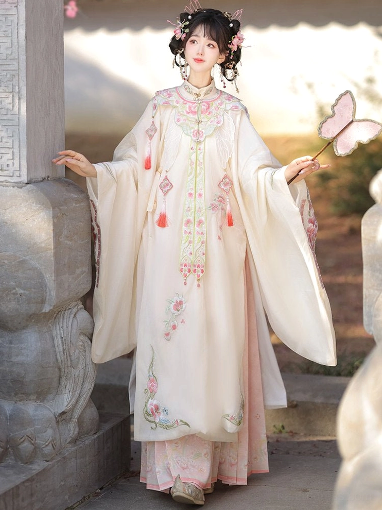Ming Dynasty Hanfu set with embroidered collar, floral robe details, pink mamian skirt, and red tassel decoration outdoors