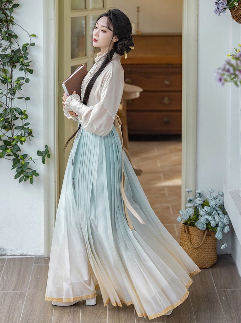Ming Dynasty inspired Hanfu outfit showing blue to cream gradient mamianqun pleats floral embroidery and gold hem trim
