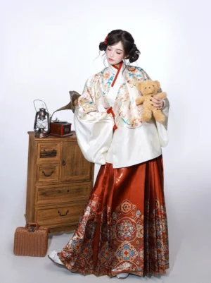 Ming Dynasty Hanfu two piece outfit with ivory embroidered pipa sleeve top and wine red woven mamian horse face skirt shown in a vintage Chinese studio