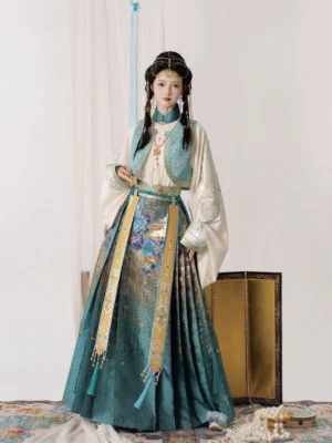 Full front view of a lake blue and ivory Ming Dynasty Hanfu complete set with gold patterned mamianqun horse face skirt, cropped vest, tassel sash, and Arabian Nights inspired ethnic styling