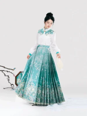Front full body view of a Ming Dynasty inspired Hanfu outfit with ivory long sleeve blouse teal cloud collar and pleated teal Mamian skirt in an oriental studio