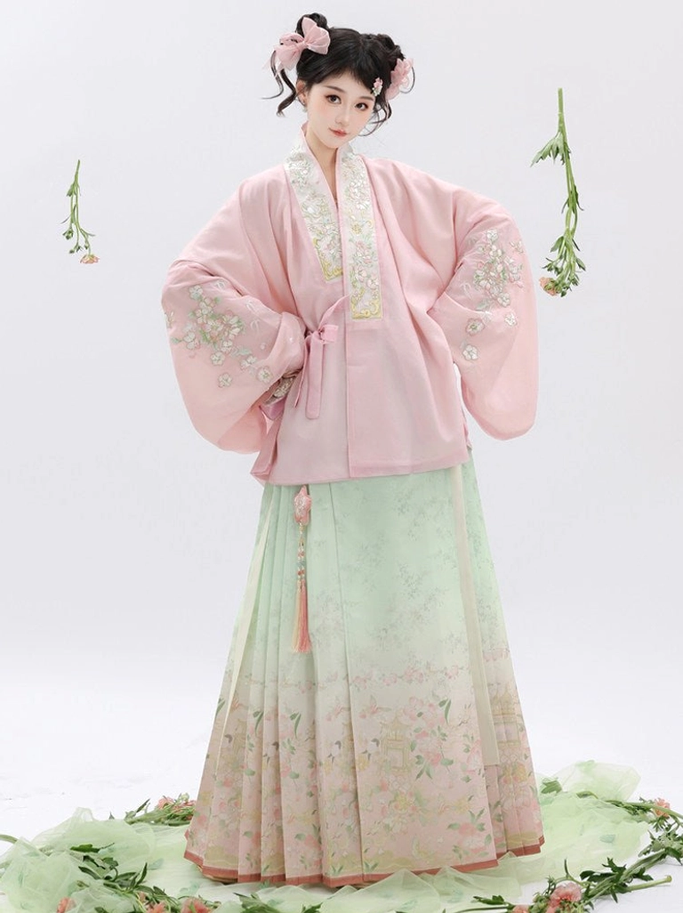 Front three-quarter view of a Ming Dynasty Hanfu set with pastel pink embroidered cross-collar top and mint pink floral mamian skirt