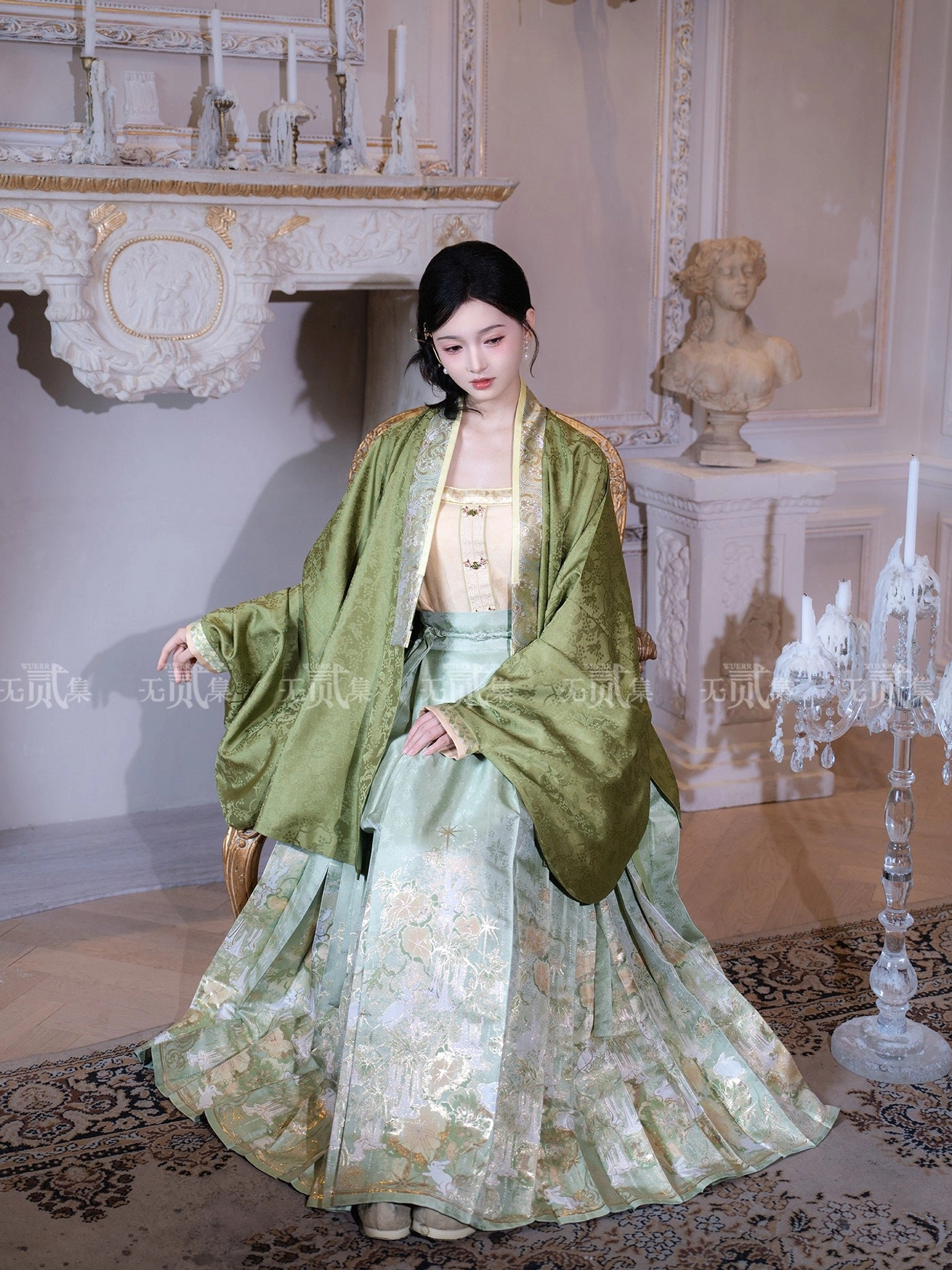 Ming Dynasty Hanfu outfit shown beside a vintage armchair with flowing pipa sleeves pleated jade green mamian skirt and golden floral details