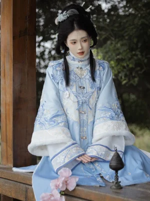 Ming Dynasty Hanfu set with sky blue embroidered robe white faux fur trim and traditional mamian skirt modeled in a Chinese pavilion