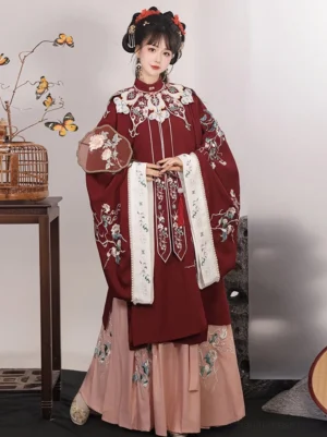 Front full-body view of a wine red Ming Dynasty Hanfu set with embroidered cloud collar, floral robe, pink pleated Mamian skirt, and traditional Chinese studio styling