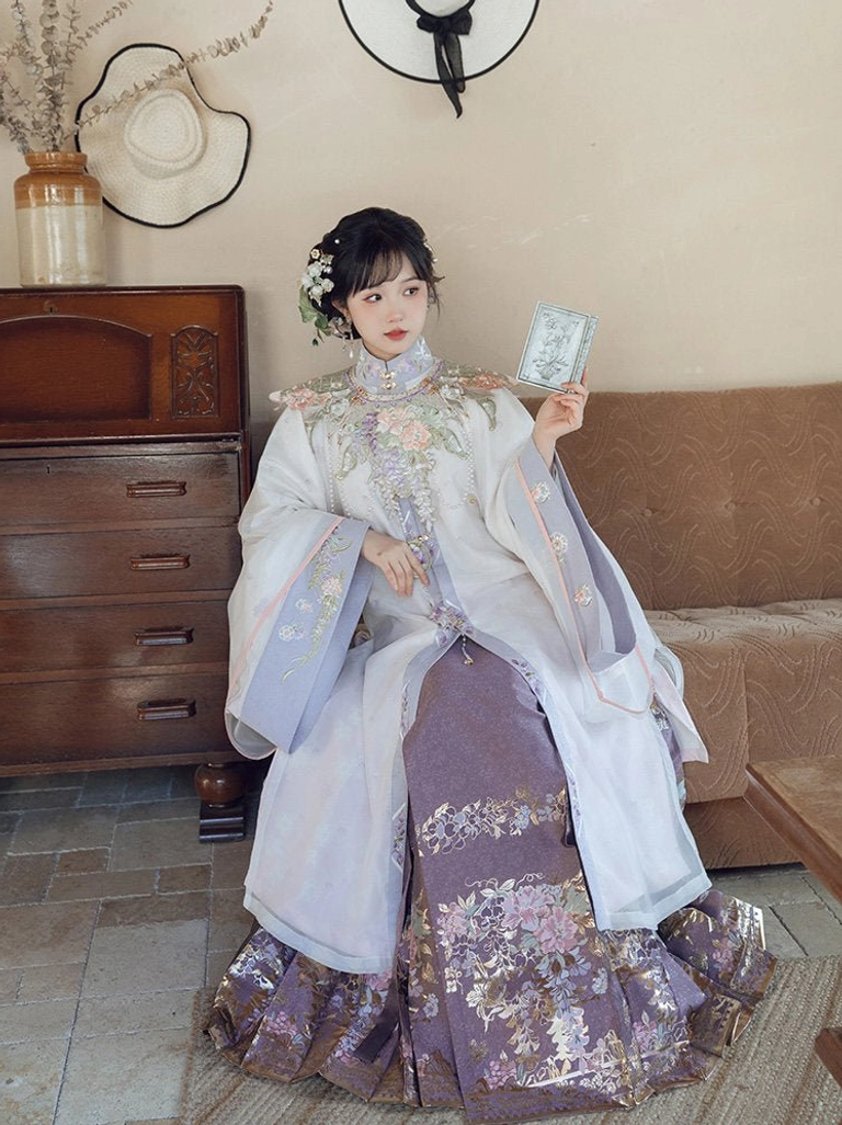 Close seated view of Ming Dynasty Hanfu robe showing stand collar violet trim frog buttons and embroidered cloud collar details