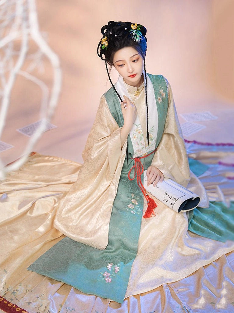 Close-up view of a two-tone satin Ming Dynasty hanfu bijia with red tassel waist decoration and soft traditional fabric texture