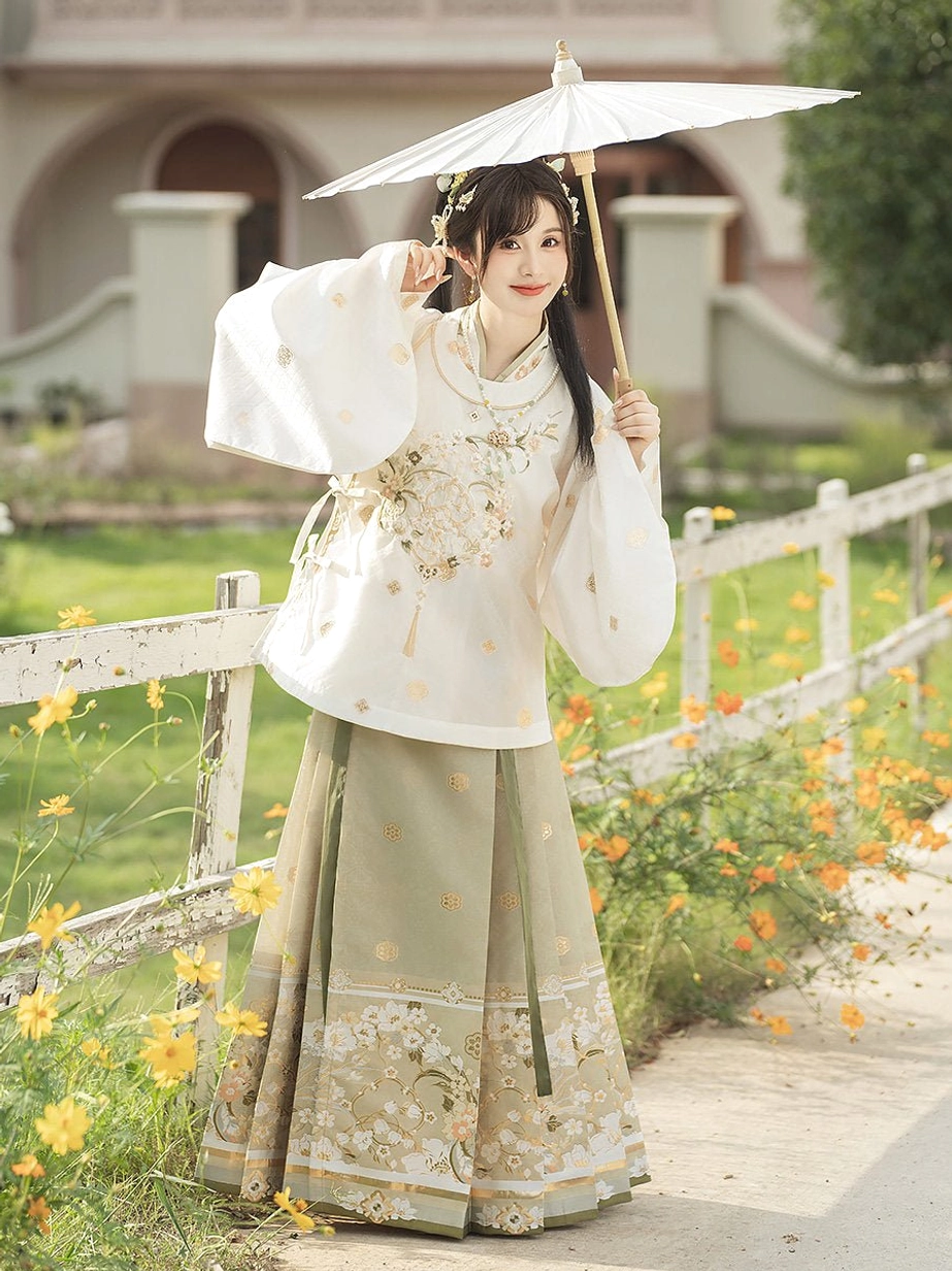 Elegant Ming Dynasty Hanfu woman wearing wide sleeve top and sage green Mamian skirt with white traditional paper umbrella outdoors