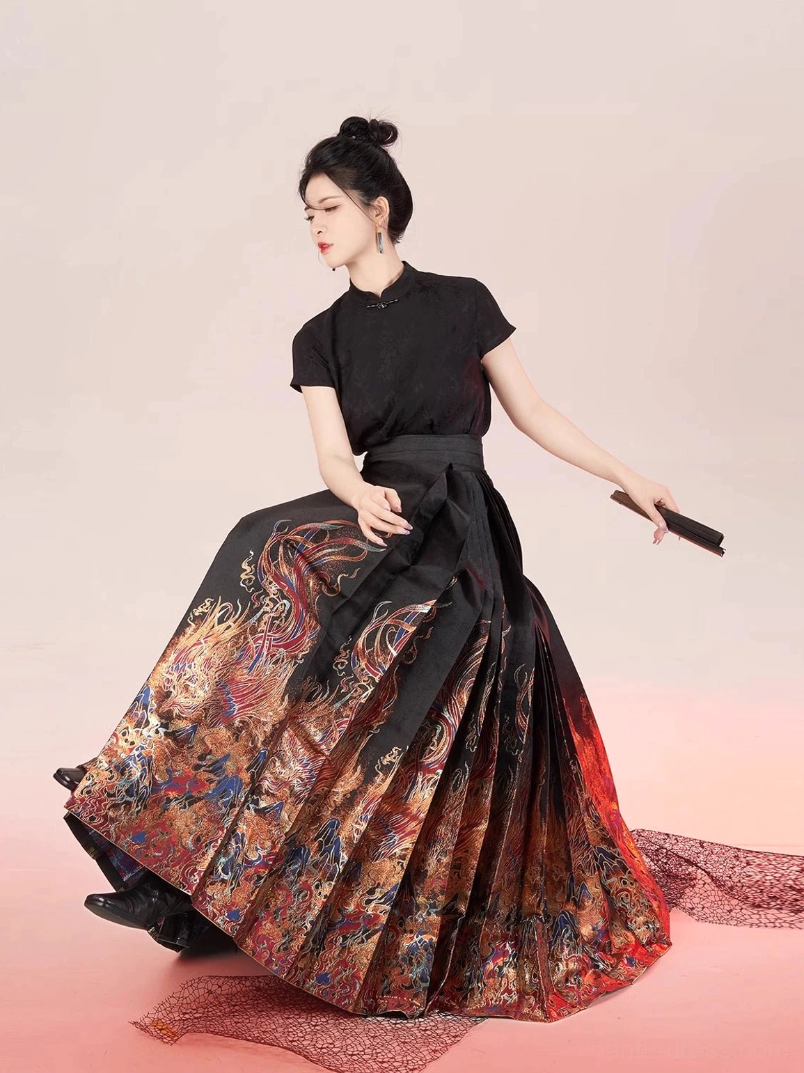 Black Chinese hanfu blouse and ruby printed mamian skirt outfit shown in a seated three-quarter studio portrait