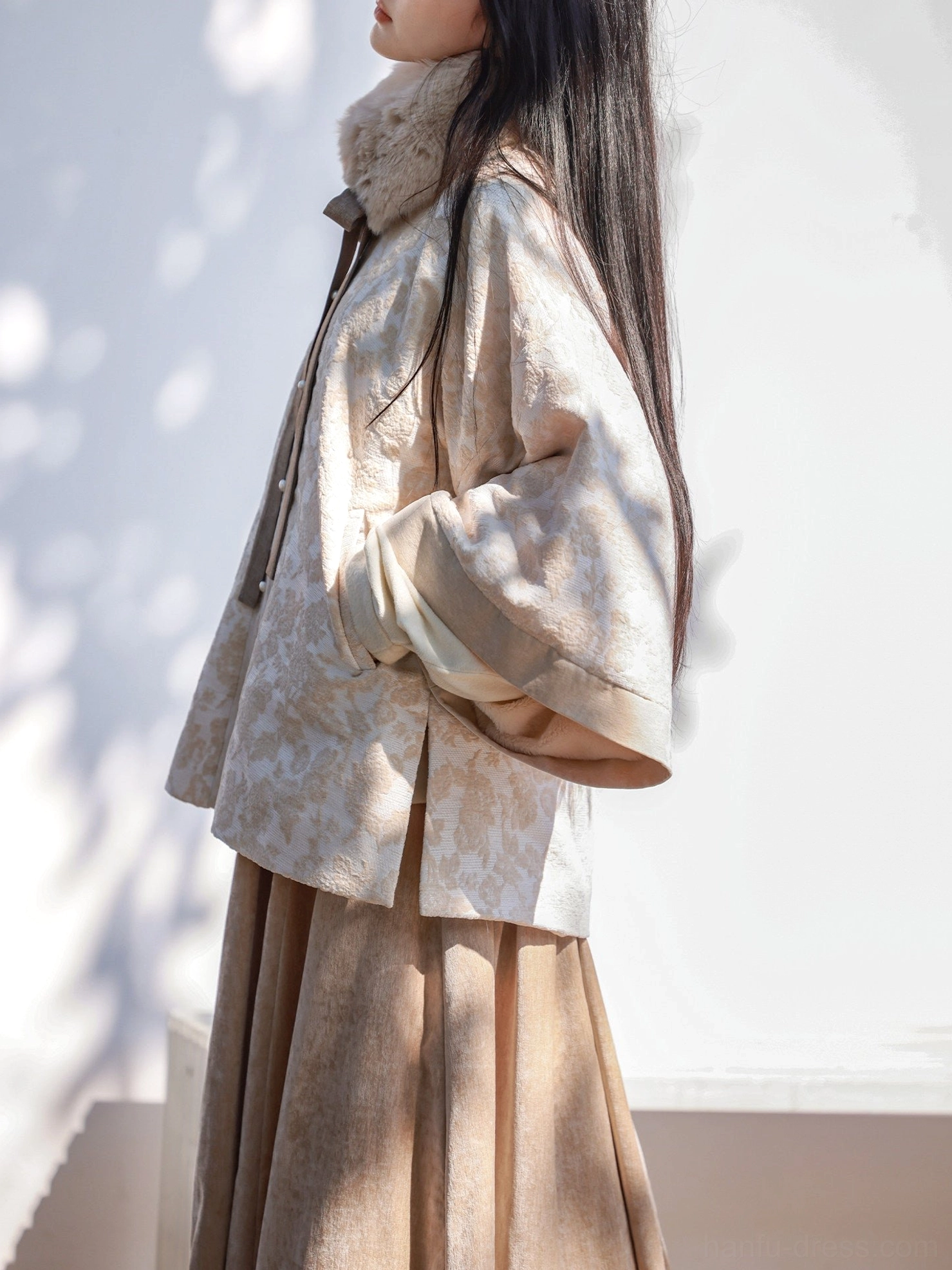 Side profile of Ming Dynasty inspired Hanfu jacket and flowing tan elastic skirt showing layered silhouette and jacket side slit