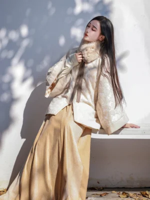 Ming Dynasty inspired modern Hanfu round collar jacket and tan elastic waist pleated skirt worn outdoors in a sunlit courtyard