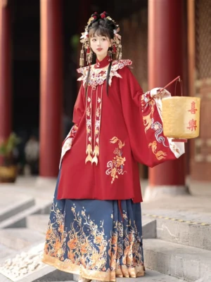 Full-body view of a Ming Dynasty wedding Hanfu set with crimson embroidered robe, navy koi mamianqun skirt, golden wave motifs, and decorative cloud collar at traditional palace stairs