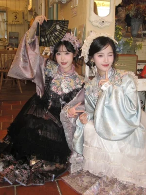 Two women wearing Ming Dynasty modern Hanfu outfits with embroidered cloud collars and layered romantic skirts in a vintage tea shop