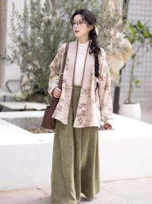 Full-body side view of a woman wearing a beige bamboo print Ming Dynasty modern Hanfu winged sleeve top with an olive green flowing long skirt in an outdoor courtyard