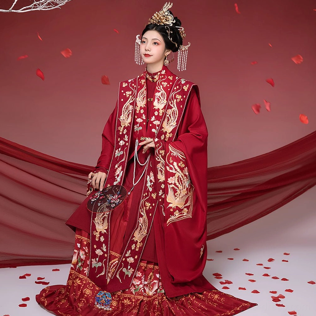 Front full-length view of a traditional Ming Dynasty red bridal Hanfu set with gold phoenix and floral embroidery, wide sleeves, xiapei sash, bridal hair ornaments, and romantic wedding styling