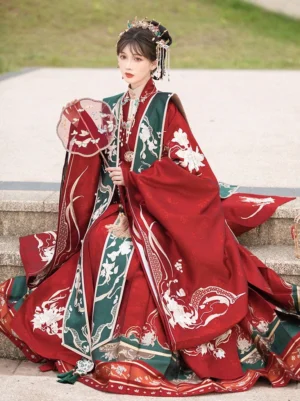 Deep red Ming Dynasty wedding Hanfu full set worn by a bride on stone steps with embroidered robe, wide sleeves, Mamian skirt, traditional hair ornaments, and round silk fan