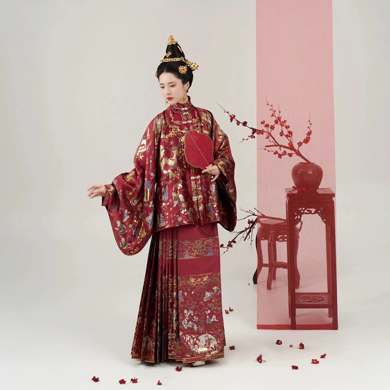 Complete red Ming Dynasty wedding Hanfu set with layered brocade tops, pleated Mamian skirt, bridal hair ornaments, and silk fan