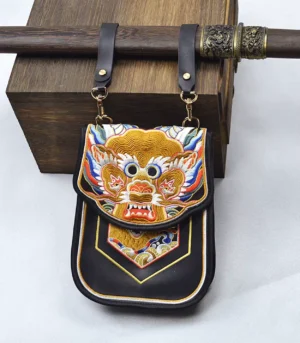 Ming style Flying Fish embroidered diexie waist pouch in black microfiber leather displayed with vintage wooden box and gold-tone hardware