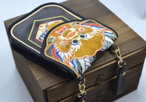 Side view of Ming Dynasty inspired Chinese embroidered bag showing dual-layer pouch construction detachable strap and colorful Flying Fish motif