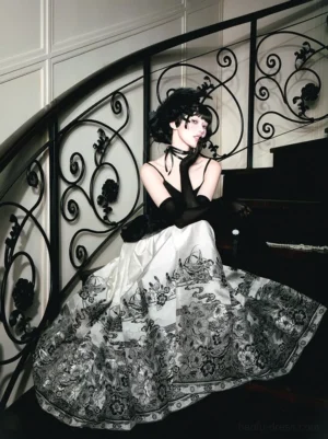 Back three-quarter view of a model wearing a black and ivory Ming-inspired printed Mamianqun horse face skirt on a vintage wrought iron staircase