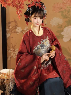 Close-up of festive Ming style Chinese New Year hanfu showing red jacquard top golden inner collar and auspicious chest embroidery