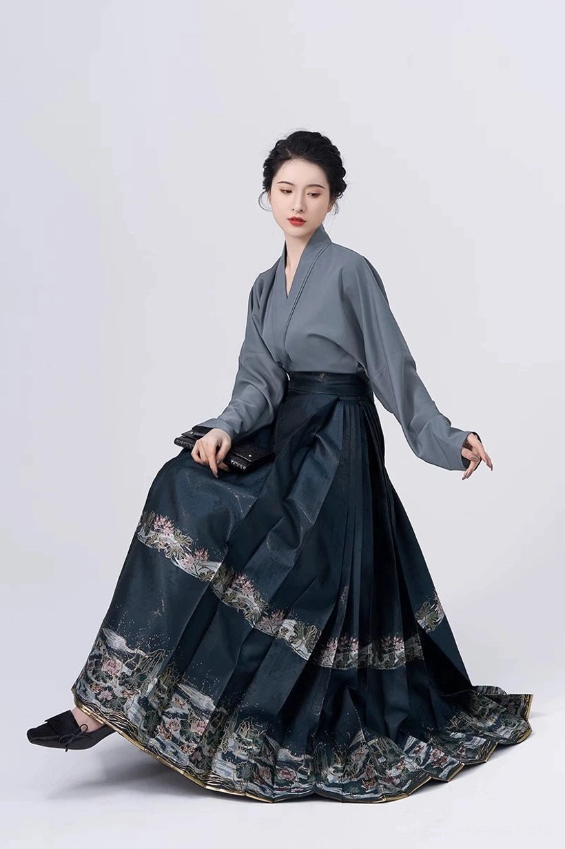 Elegant Ming-inspired Hanfu cross-collar blouse and floor-length dark teal embroidered mamian skirt in a three-quarter view
