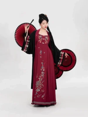 Three-quarter view of a Ming-inspired Hanfu set showing the black embroidered outer robe layered over a wine-red dress