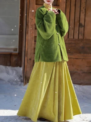 Ming-inspired Hanfu green chenille round collar jacket with pale yellow elastic waist skirt shown in a snowy outdoor cabin setting side view