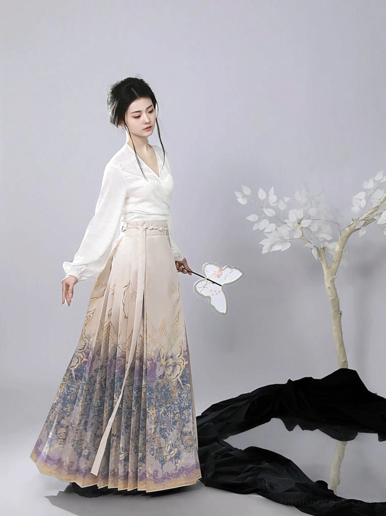 Front view of an elegant Ming inspired hanfu outfit with white wrap blouse and ombre mamianqun horse face skirt decorated with gilded traditional prints