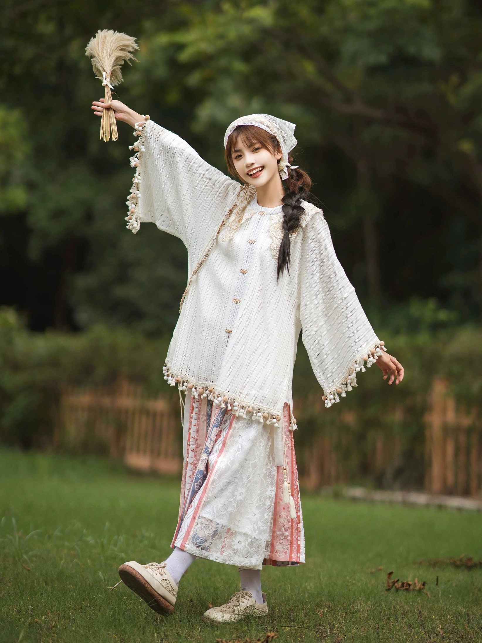 Full body outdoor view of Ming-inspired modern Hanfu blouse and printed wrap skirt outfit with tassel trim