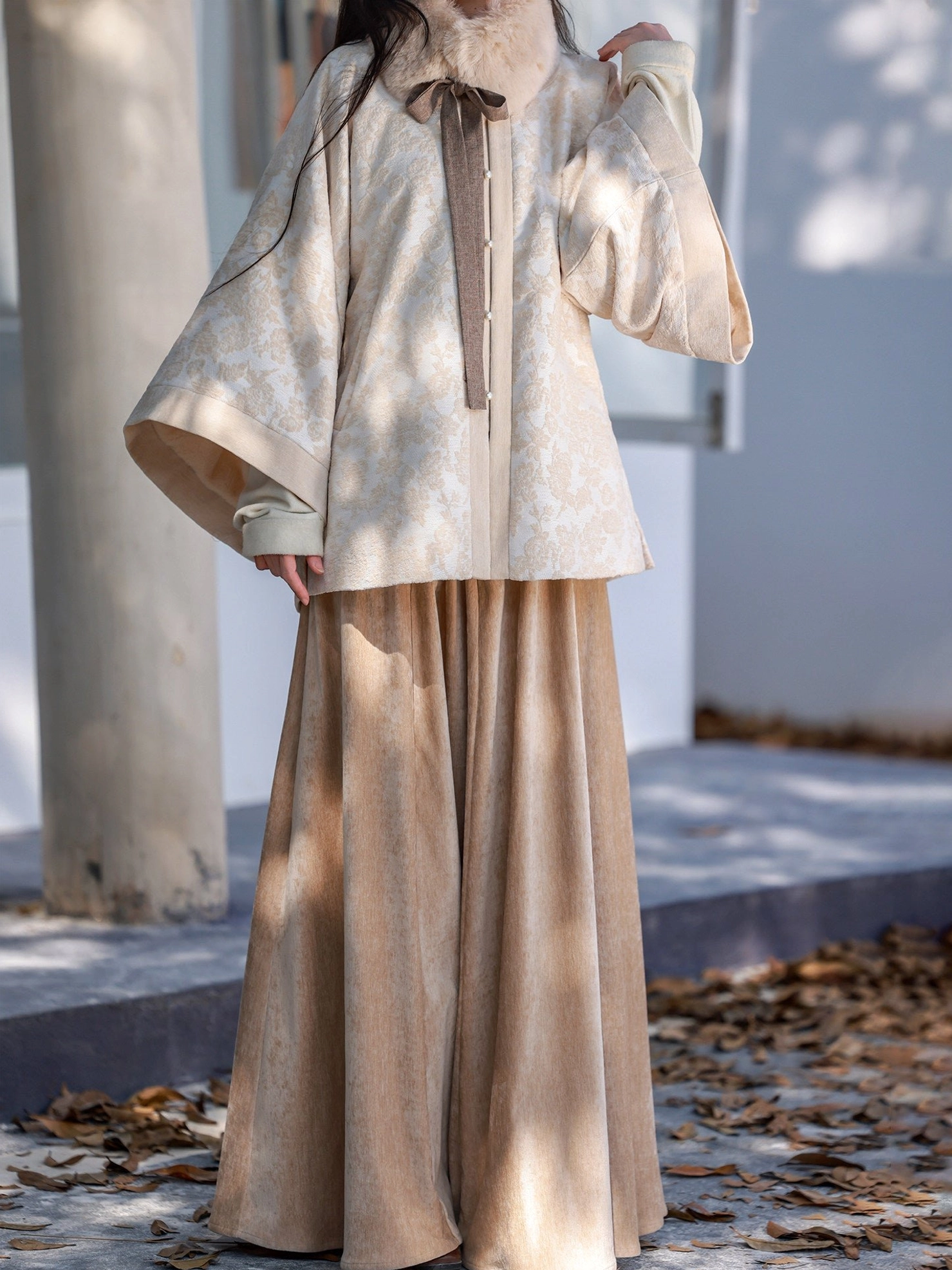 Close view of beige Ming style Hanfu round collar jacket with jacquard texture button front and contrast trimmed wide sleeves