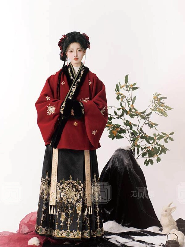 Ming-style Hanfu upper garment in deep red with white floral print, black fur-trimmed cross-collar placket, and decorative sleeve tassels