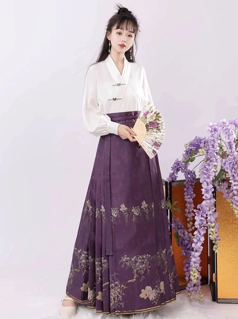 Front view of a Ming-style Hanfu mamianqun complete set featuring a white cross-collar top, neatly pleated purple skirt, golden wisteria prints, and folding fan