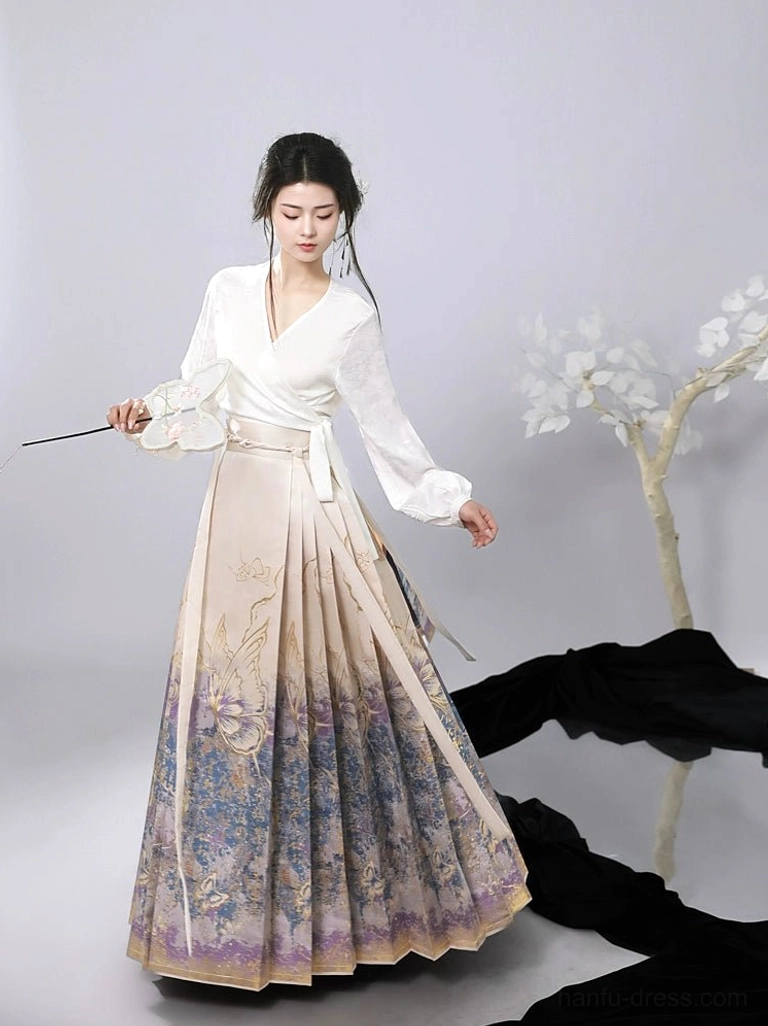 Ming style modern mamianqun hanfu skirt paired with a white wrap blouse and waist sash, featuring gold foil butterfly and floral motifs on a pleated ombre skirt