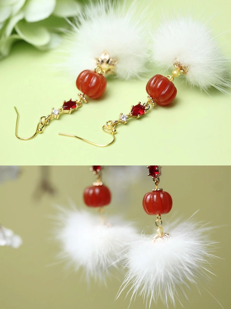 Pair of white mink fur pompom Chinese earrings with red pumpkin resin beads and gold hook ear wires top view